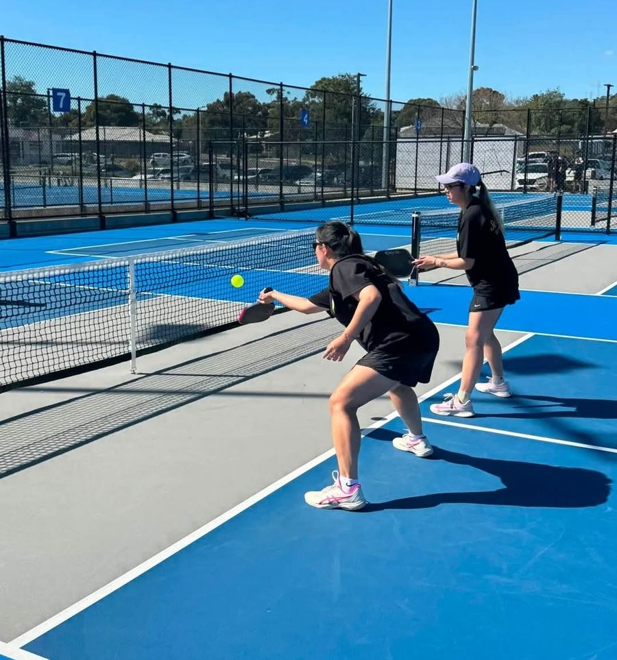 Two players mid-rally during a doubles game