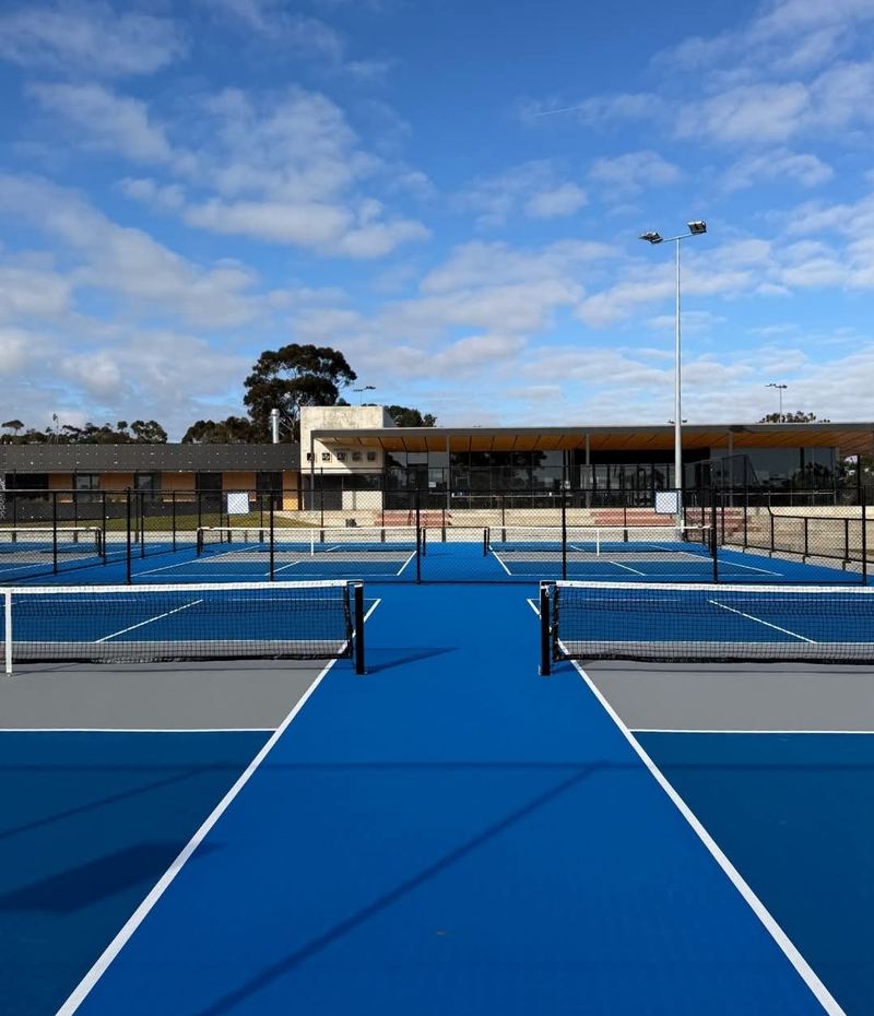 Empty pickleball courts and clubhouse at Voyager Tennis Academy
